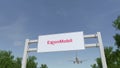 Airplane flying over advertising billboard with ExxonMobil logo. Editorial 3D rendering