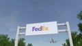 Airplane flying over advertising billboard with FedEx logo. Editorial 3D rendering Royalty Free Stock Photo