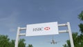 Airplane flying over advertising billboard with HSBC logo. Editorial 3D rendering