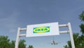 Airplane flying over advertising billboard with Ikea logo. Editorial 3D rendering