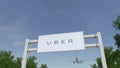 Airplane flying over advertising billboard with Uber Technologies Inc. logo. Editorial 3D rendering Royalty Free Stock Photo