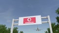 Airplane flying over advertising billboard with Vodafone logo. Editorial 3D rendering Royalty Free Stock Photo