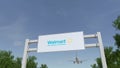 Airplane flying over advertising billboard with Walmart logo. Editorial 3D rendering