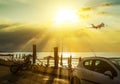 Airplane flying over blur people relax on tropical sunset beach with bokeh sun light wave abstract background. Copy space of Royalty Free Stock Photo