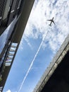 Airplane flying over between modern architecture and expressway. Royalty Free Stock Photo