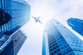 Airplane flying over modern glass and steel office buildings in singapore Royalty Free Stock Photo