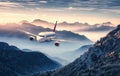 Airplane is flying over mountains in fog at beautiful sunset Royalty Free Stock Photo