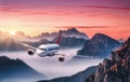 Airplane is flying over mountains in fog at colorful sunset Royalty Free Stock Photo