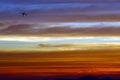 airplane flying over the rainbow and blue sky red orange yellow cloud in sunset Royalty Free Stock Photo