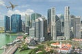 Airplane flying over Singapore business district in morning