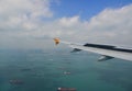 Airplane flying over the Singapore sea Royalty Free Stock Photo