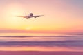Airplane flying over tropical beach with smooth wave and sunset sky abstract background Royalty Free Stock Photo