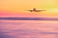 Airplane flying over tropical beach with smooth wave and sunset sky abstract background Royalty Free Stock Photo