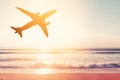 Airplane flying over tropical beach with smooth wave and sunset sky abstract background Royalty Free Stock Photo