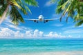 Airplane flying over tropical palm trees on a blue sky background. Plane arrival at the beach Royalty Free Stock Photo