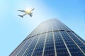 Airplane flying past a modern skyscraper, Royalty Free Stock Photo