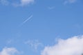 Airplane flying through the sky leaving a white trail through the clouds