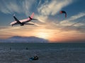 Airplane flying through a surf kite over the sea at dusk Royalty Free Stock Photo