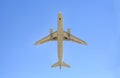 Airplane flying under blue sky. Seen from below Royalty Free Stock Photo