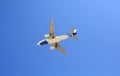 Airplane flying under blue sky. Seen from below Royalty Free Stock Photo