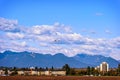 Airplane flying under the clouds over the buildings Royalty Free Stock Photo