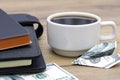 An airplane folded from a banknote as a symbol of success. Coffee and notebook on the table Royalty Free Stock Photo