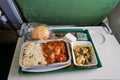 Airplane food, rice and chicken meat with beans salad, on tray table