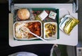 Airplane food, rice and chicken meat with beans salad, on tray table