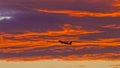 Airplane in front of illuminated clouds at afterglow Royalty Free Stock Photo