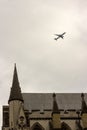 An airplane glides over the rooftop of the British Parliament building in London, England.