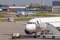 Airplane with a ladder ladder waiting for passengers, in the distance against the background of a landed liner taxied into the Royalty Free Stock Photo