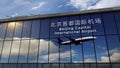 Airplane landing at Beijing Capital China mirrored in terminal