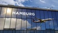 Airplane landing at Hamburg Germany airport mirrored in terminal