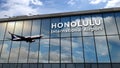 Airplane landing at Honolulu Hawaii, USA airport mirrored in terminal Royalty Free Stock Photo