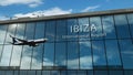 Airplane landing at Ibiza Spain airport mirrored in terminal