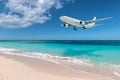 Airplane landing over beautiful beach. Royalty Free Stock Photo