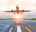 Airplane landing on the runway at the airport at sunset dawn Royalty Free Stock Photo