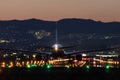 Airplane landing to the airport at dusk Royalty Free Stock Photo