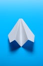 Airplane made of white paper on a blue background Royalty Free Stock Photo