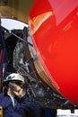 Airplane mechanic inspecting jet engine