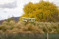 Airplane model flying over tall grass The background of colorful autumn trees