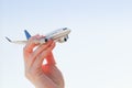 Airplane model in hand on sunny sky. Travel, transportation Royalty Free Stock Photo