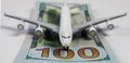 Airplane model on runway of 100 dollar paper money bills (focus on 100 Royalty Free Stock Photo
