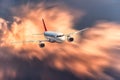 Airplane with motion blur effect is flying in big orange clouds at sunset. Passenger airplane, blurred clouds Royalty Free Stock Photo