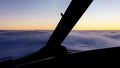 Airplane moves above the cloudness sky on sunset.Camera in cabin of pilot