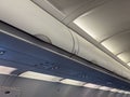 Airplane overhead compartments and ceiling. Aviation design, passenger service, and storage inside cabin. Royalty Free Stock Photo