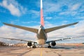 Airplane parked at the airport against the background of a blue sky with clouds, rear view Royalty Free Stock Photo