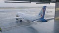 Airplane parking in the airport hangar. Airplane in hangar, rear view of aircraft and light from windows. Roll-out of