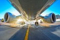 Airplane in the parking lot of the airport apron, bottom view hdr of engines, fuselage and wings. Royalty Free Stock Photo