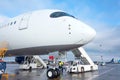 Airplane in parking lot with gangway in the open air at the airport, nose view with pilot`s cabin